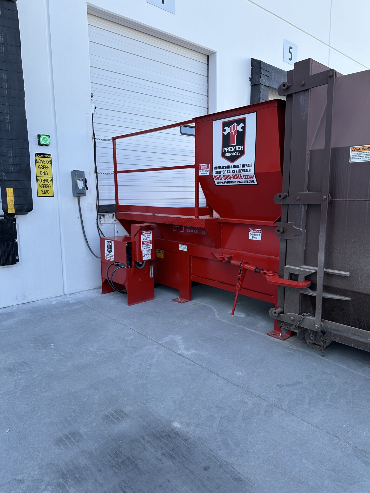 Dock-mounted compactor with container and green safety indicator