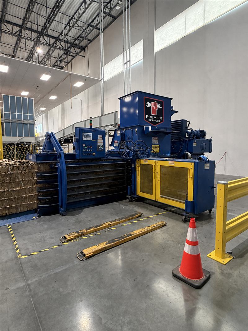 Blue horizontal baler installed in a warehouse